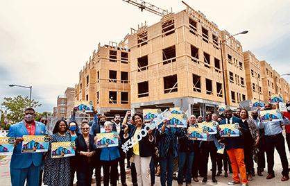 Mayor Bowser holding sign that says #3600by2025